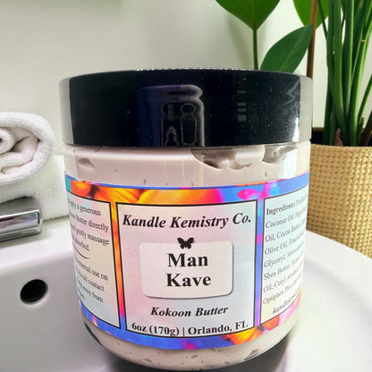 Jar of Man Kave Kokoon Butter by Kandle Kemistry Co. on a bathroom counter with a plant in the background.