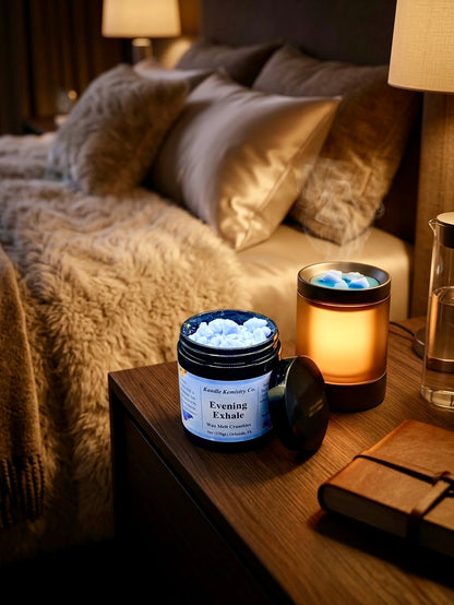 Jar of 'Evening Exhale' wax melts on a bedside table with a lit candle and notebook in a cozy bedroom setting.