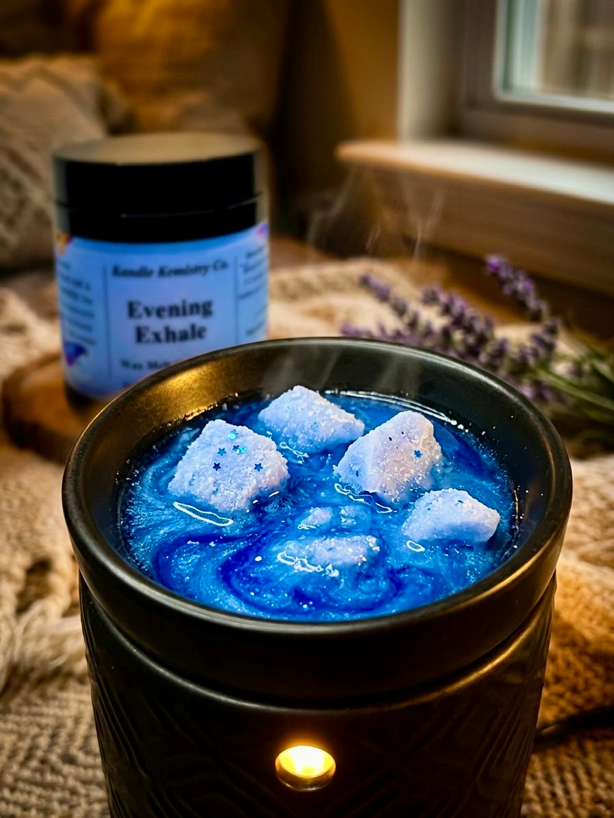 Black wax melt warmer with blue melted wax melt crumbles, next to jar labeled 'Evening Exhale'.