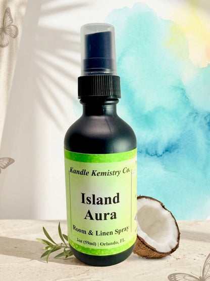 Bottle of Island Aura room and linen spray with a coconut and leaves on a light background