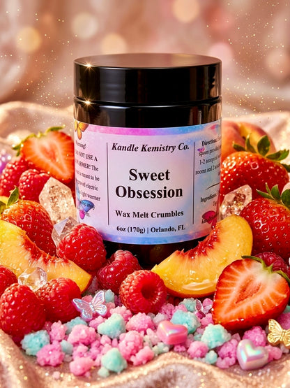 Jar of 'Sweet Obsession' wax melt crumbles surrounded by strawberries and candy on a glittery background