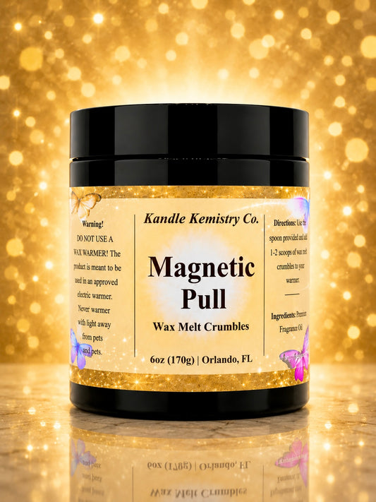 A jar of Kandle Kemistry Co. Magnetic Pull Wax Melt Crumbles, 6 oz (170g), shown on a reflective gold surface with a sparkling gold bokeh background.