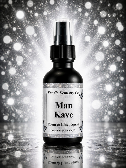 A 2 oz room and linen spray bottle from Kandle Kemistry Co. labeled 'Man Kave', shown against a sparkling silver and black bokeh background with a reflective surface below.