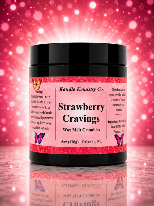 A jar of Kandle Kemistry Co. Strawberry Cravings Wax Melt Crumbles, featuring a black jar and a pink label with butterfly illustrations, set against a sparkling pink background with a reflection below.