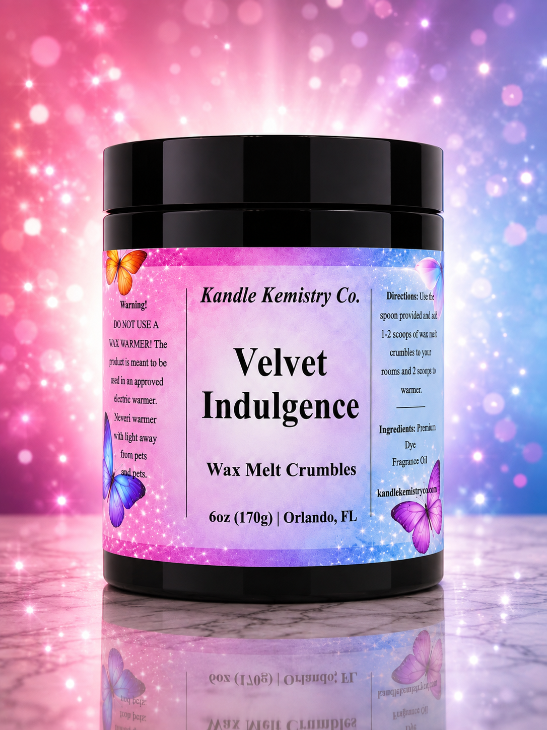 A black plastic jar of Kandle Kemistry Co. Velvet Indulgence Wax Melt Crumbles, featuring a colorful label with butterflies and a pink-to-blue gradient, set against a sparkling pink and blue bokeh background.