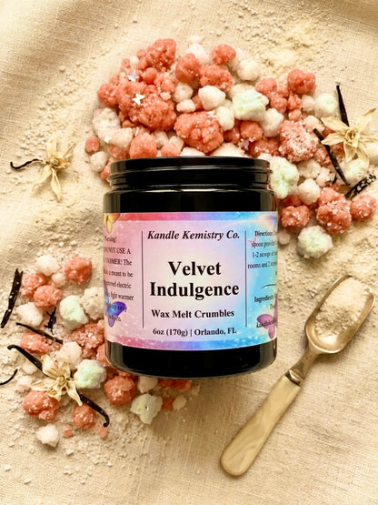 Jar of 'Velvet Indulgence' wax melt crumbles with decorative elements on a textured surface.